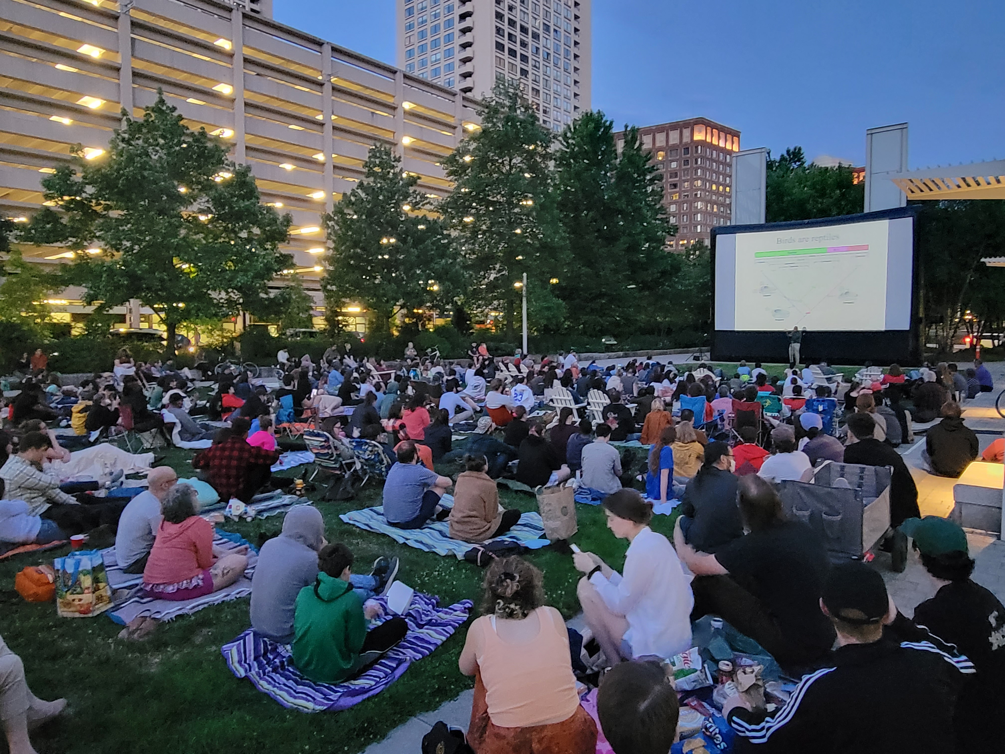 People gathered at the Greenway watching an outdoor movie